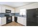 Updated kitchen featuring white cabinets, black appliances, and granite countertops at 1316 Hackett St, Mount Dora, FL 32757