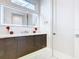 Modern bathroom with sleek vanity, illuminated mirror, and marble flooring at 1544 Corolla Ct, Reunion, FL 34747