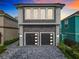 Contemporary home with gray stone exterior and a two-car garage at 1544 Corolla Ct, Reunion, FL 34747