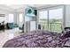 Main bedroom with a plush bed, golf course view, and private balcony access at 1544 Corolla Ct, Reunion, FL 34747