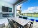 Covered patio with fireplace, dining area, and pool view at 1544 Corolla Ct, Reunion, FL 34747
