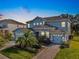 Stunning two-story home with light blue exterior and stone accents at dusk at 1457 Olympic Club Blvd, Champions Gate, FL 33896