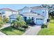Two-story house with light blue exterior, stone accents, and a three-car garage at 1457 Olympic Club Blvd, Champions Gate, FL 33896
