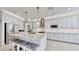 Modern kitchen with white cabinets, granite countertops, and large island at 1457 Olympic Club Blvd, Champions Gate, FL 33896