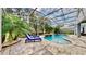 Relaxing pool area with patio furniture under a screened-in enclosure at 1457 Olympic Club Blvd, Champions Gate, FL 33896