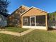 Home's back exterior, showcasing a screened porch and yard at 124 Dakota Ave, Groveland, FL 34736