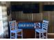 Home bar with three mounted TVs and blue barstools at 124 Dakota Ave, Groveland, FL 34736