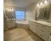 Spa-like bathroom with double vanity, corner tub, and tile flooring at 124 Dakota Ave, Groveland, FL 34736