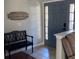 Inviting entryway with a gray door, a black bench, and a wood sign at 124 Dakota Ave, Groveland, FL 34736