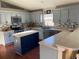 Updated kitchen boasts blue cabinets, a large island, and stylish backsplash at 124 Dakota Ave, Groveland, FL 34736