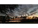 Scenic sunset view over a tranquil lake, with lush trees and a white fence at 124 Dakota Ave, Groveland, FL 34736