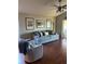 Bright living room with hardwood floors, comfy seating, and built-in shelving at 124 Dakota Ave, Groveland, FL 34736