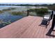 Wooden dock with a bench, providing a serene spot to enjoy views of the calm lake and natural wetland vegetation at 2488 Hartridge Point W Dr # 2488, Winter Haven, FL 33881