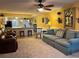 Open-concept living room features a neutral-toned carpet, ceiling fan, and flows into the kitchen with a breakfast bar at 2488 Hartridge Point W Dr # 2488, Winter Haven, FL 33881