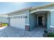 Front entrance with white garage door and stone accents at 7865 Sw 89Th Cir, Ocala, FL 34481