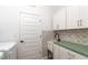 Laundry room with teal countertop, patterned tile, and built-in cabinets at 7865 Sw 89Th Cir, Ocala, FL 34481