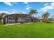 Expansive backyard with lush green lawn and a screened lanai for outdoor enjoyment at 8007 Acadia Estates Ct, Kissimmee, FL 34747