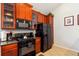 Modern kitchen with wood cabinets and black appliances at 8007 Acadia Estates Ct, Kissimmee, FL 34747