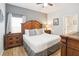 Comfortable main bedroom featuring a large bed, wooden furniture and light-filled window at 8007 Acadia Estates Ct, Kissimmee, FL 34747
