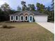 Single-story house with a gray exterior, light-colored garage, and a small front yard at 15900 Sw 19Th Avenue Rd, Ocala, FL 34473