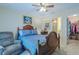 Cozy bedroom featuring a wooden bed frame, recliner, and access to an ensuite bathroom and walk-in closet at 12854 Sw 77Th Cir, Ocala, FL 34473