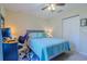 Bright bedroom with a ceiling fan, a full-sized bed, and a built-in workspace with storage at 12854 Sw 77Th Cir, Ocala, FL 34473