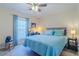 Bedroom featuring natural light, a ceiling fan, large window, and a dedicated workspace at 12854 Sw 77Th Cir, Ocala, FL 34473