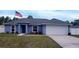 Newly built home with blue exterior, white fence, and a two-car garage at 12854 Sw 77Th Cir, Ocala, FL 34473