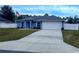 Newly built home with blue exterior, white fence, and a two-car garage at 12854 Sw 77Th Cir, Ocala, FL 34473