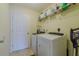 Functional laundry room with modern appliances, storage shelves, and neutral paint at 12854 Sw 77Th Cir, Ocala, FL 34473