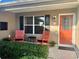 Inviting front porch with rocking chairs and vibrant landscaping at 457 Enright Pl, The Villages, FL 32162