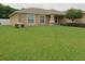 House exterior showcases a tan facade and lush green lawn at 4852 Magnolia Preserve Dr, Winter Haven, FL 33880