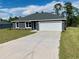 Newly constructed home with gray exterior, white garage door, and landscaped lawn at 6459 Sw 204Th Ave, Dunnellon, FL 34431