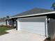 Gray house with white garage door and landscaping at 6459 Sw 204Th Ave, Dunnellon, FL 34431