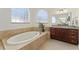 Elegant bathroom with a large soaking tub and granite countertops at 11276 Se 170Th Pl, Summerfield, FL 34491