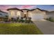 One-story house exterior at dusk, featuring a two-car garage and landscaping at 11276 Se 170Th Pl, Summerfield, FL 34491