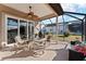 Relaxing screened patio with seating area, ceiling fan, and grill at 11276 Se 170Th Pl, Summerfield, FL 34491