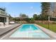 Inviting in-ground pool with an adjoining sun deck, a volleyball net, and landscaped backyard at 301 Rippling Ln, Winter Park, FL 32789