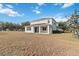 Two-story house with grassy backyard and partial view of neighborhood at 2016 Sanderlin Point Loop, Apopka, FL 32703