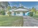 White house with teal doors, covered patio, and a large grassy yard at 270 N 1St St, Lake Mary, FL 32746