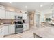 Bright kitchen with white cabinets, stainless steel appliances, and light-colored countertops at 461 Troy Loop, The Villages, FL 32162