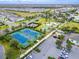 An aerial view of the tennis and sport courts with adjacent parking in a well-maintained community at 220 Clawson Way, Kissimmee, FL 34747