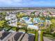 Aerial view of community water park with pools, slides, and lounging areas surrounded by lush landscaping at 220 Clawson Way, Kissimmee, FL 34747