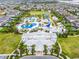 Aerial view of community water park with pools, slides, and lounging areas surrounded by lush landscaping at 220 Clawson Way, Kissimmee, FL 34747