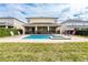 A backyard featuring a swimming pool and spa and patio space with comfortable lounge chairs at 220 Clawson Way, Kissimmee, FL 34747