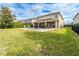 Spacious backyard features a pool, covered patio, and well-maintained lawn, perfect for outdoor entertaining at 220 Clawson Way, Kissimmee, FL 34747