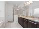 Well-lit bathroom with granite counters, dual sinks, and a glass-enclosed shower, offering modern convenience at 220 Clawson Way, Kissimmee, FL 34747
