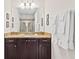 Bathroom vanity with dark cabinets, granite counters, and a mirror reflecting a glass-enclosed shower at 220 Clawson Way, Kissimmee, FL 34747