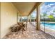 This covered patio offers a tiled floor, ceiling lighting and outdoor dining set next to the pool at 220 Clawson Way, Kissimmee, FL 34747