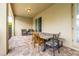 This tiled covered patio area offers ceiling lighting and an outdoor dining set at 220 Clawson Way, Kissimmee, FL 34747